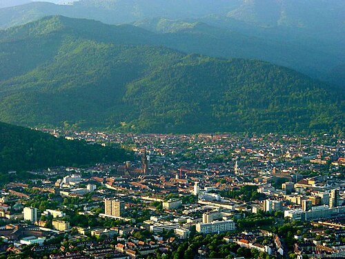 Blick über die Altstadt von Freiburg im Breisgau mit dem Münster und den bewaldeten Höhen des Schwarzwalds